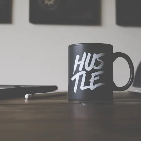 a black mug with hustle written on it