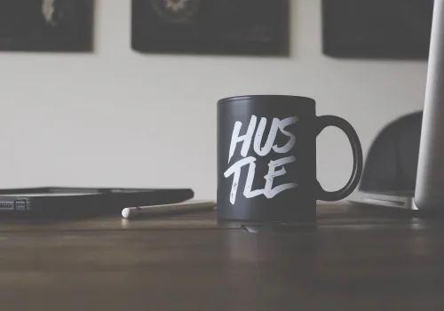 a black mug with hustle written on it