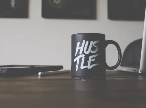 a black mug with hustle written on it